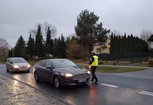 Policjant bada stan trzeźwości kierującego pojazdem