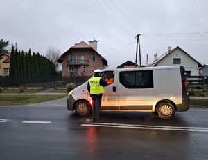 Policjant bada stan trzeźwości kierującego pojazdem