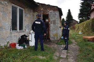 Policjanci rozmawiają z mężczyzną przed wejściem do jego domu