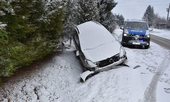 Samochód w przydrożnym rowie. W tle policyjny radiowóz