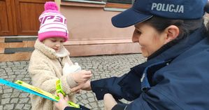 Policjantka zakłada odblask małemu dziecku