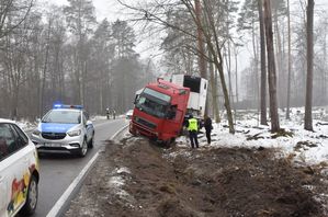 Pojazd ciężarowy w rowie. Na jezdni znajduje się radiowóz oraz samochody osobowe.