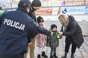 Policjantka rozdaje odblaski dzieciom