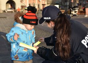 Policjanta daje dziecku odblask