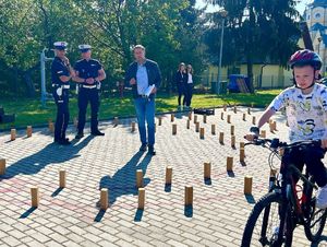 Dziecko w czasie konkursu rowerowego. W tle policjanci