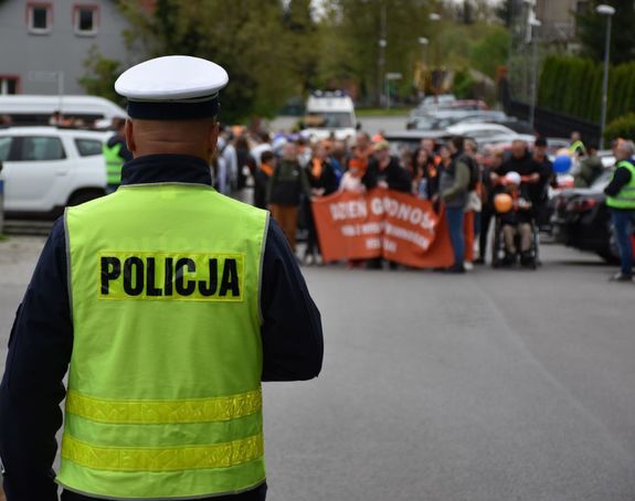Policjant zabezpiecza na drodze marsz godności