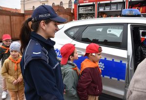 Policjantka z dziećmi przed raiowozem
