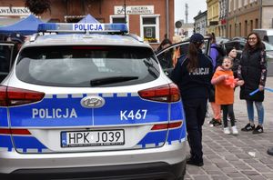 Radiowóz. W tle policjantka i dzieci