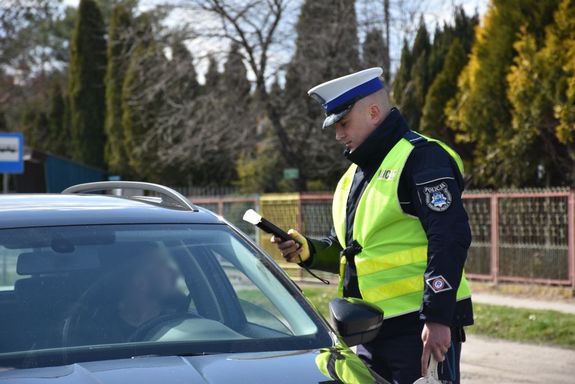 Policjant bada stan trzeźwości kierującego pojazdem