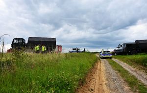 Droga polna. W tle radiowóz oraz samochód wojakowy