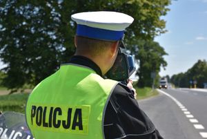 Policjant dokonuje pomiaru prędkości przejeżdżającym drogą kierowcom