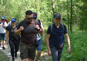 Kobiety i mężczyźni idą leśnym szlakiem