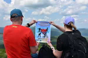 Kobieta i mężczyzna trzymają w rekach plakat promujący akcję charytatywną wiosna na sportowo