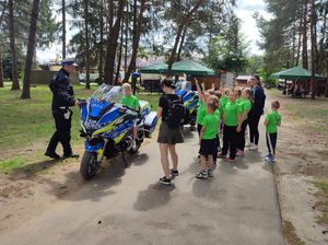Policjant rozmawia z dziećmi w trakcie pikniku