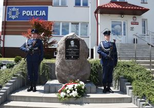 Policjanci przy upamiętniającej tablicy generała Marka Papały