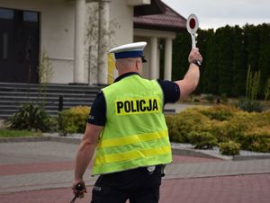 Policjant na drodze daje sygnał do zatrzymania kierującemu pojazdem