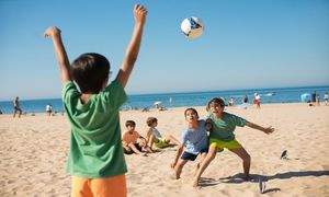 Dzieci grają w piłkę na plaży