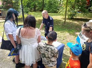 Dzieci i dorośli przed stoiskiem profilaktycznym Policji