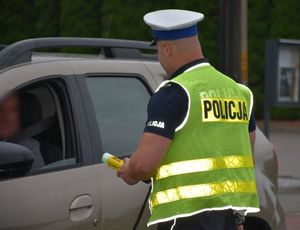 Policjant bada stan trzeźwości kierującego pojazdem
