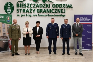 Policjanci i uczestnicy spotkania podczas podpisania porozumienia o utworzeniu klas o profilu mundurowym. Uczestnicy siedzą przy stołach w Bieszczadzkim Oddziale Straży Granicznej w Przemyślu.