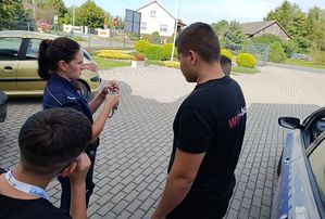 Policjantka i chłopiec z kajdankami w ręce