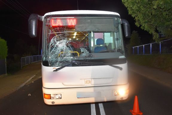 Pora nocna. Autobus z pęknięta przednią szybą stoi na drodze.
