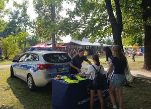 Dzieci na pikniku. W tle radiowóz