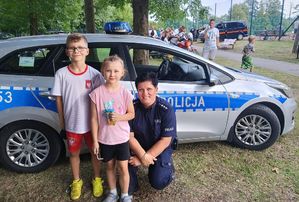 Dzieci z policjantką przy radiowozie
