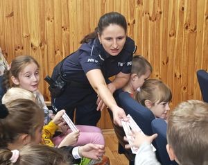 Policjantka rozdaje dzieciom odblaski