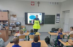 Policjantka pokazuje dzieciom umundurowanie.