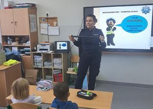 Policjantka pokazuje dzieciom pałkę służbową.