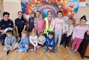 Zdjęcie grupowe dzieci z policjantkami na tle ścianki z balonami