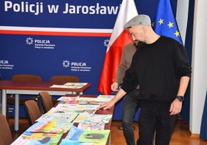 Mężczyzna przyglądający się pracom plastycznym