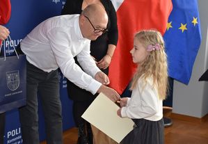 Mężczyzna wręcza nagrodę małej dziewczynce