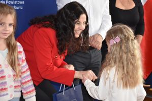 Kobieta wręcza nagrodę małej dziewczynce