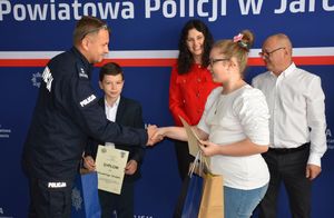 Policjant wręcza nagrodę dziewczynce