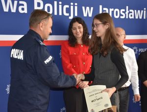 Policjant wręcza nagrodę dziewczynie