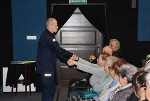 Policjant podczas pokazu udzielania pierwszej pomocy przedmedycznej seniorce