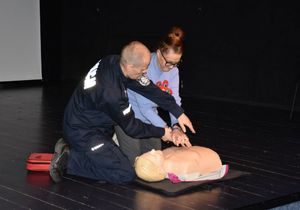 Policjant uczy seniorkę wykonywać masaż serca