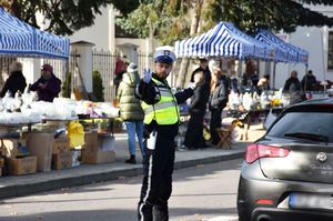 Policjant kieruje ruchem na drodze w okolicy cmentarza