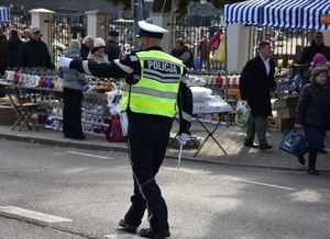 Policjant kieruje ruchem na drodze w okolicy cmentarza