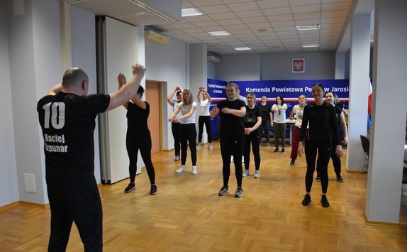 Kobiety ćwiczą na sali z instruktorem