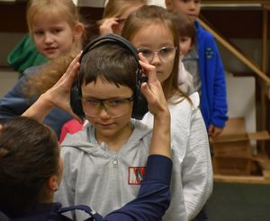 Dziecko z założonymi słuchawkami i okularami