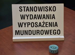 Tabliczka z napisem Stanowisko do wydawania wyposażenia mundurowego