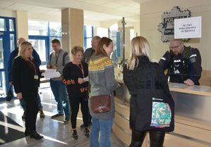 Kobiety i mężczyźni przy wejściu do komendy