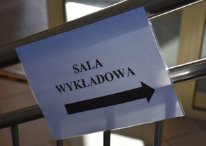Napis o treści Sala wykładowa ze strzałką