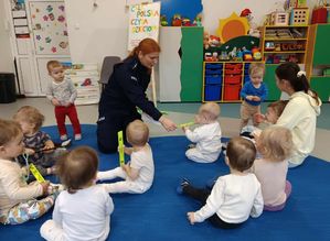 Policjantka czyta dzieciom bajki w żłobku