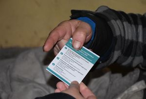 Policjantka wręcza mężczyźnie ulotkę