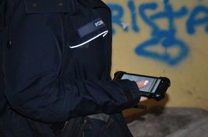 Policjantka trzyma w ręce urządzenie do sprawdzania danych