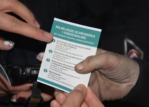 Policjantka wręcza ulotkę kobiecie